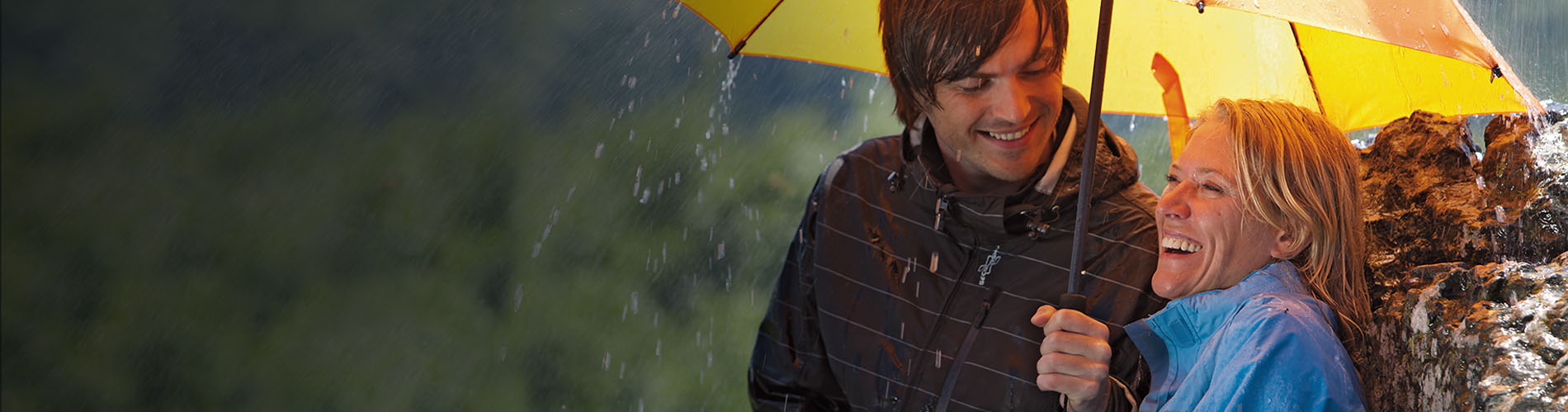 Homme et une dame en randonnée avec un parapluie de randonnée et de trekking jaune