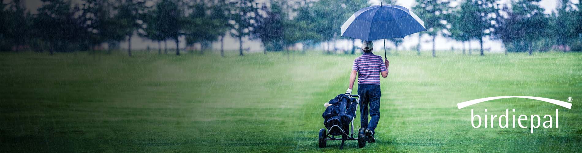 Homme sur un terrain de golf tient un parapluie extra large à double revêtement dans sa main.